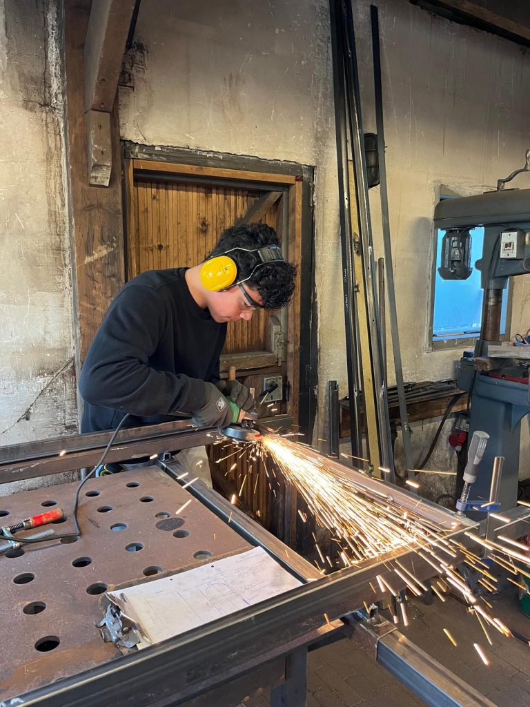 Smeed&Laswerk 8 a man using a grinder to cut metal