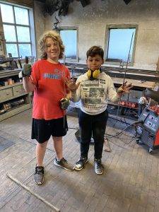 De volgende generatie: mijn zoon in de smederij 2 zoon met vriend in de werkplaats