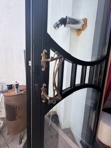 Moderne glazen deur met zwart frame, elegante patronen en stijlvolle woningachtergrond.