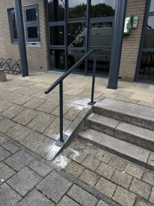 Project: Stalen trapleuning bij Tandartspraktijk De Witte Brug – Papendrecht 3 Detail van stalen leuning in RAL 7021 op twee voetplaten